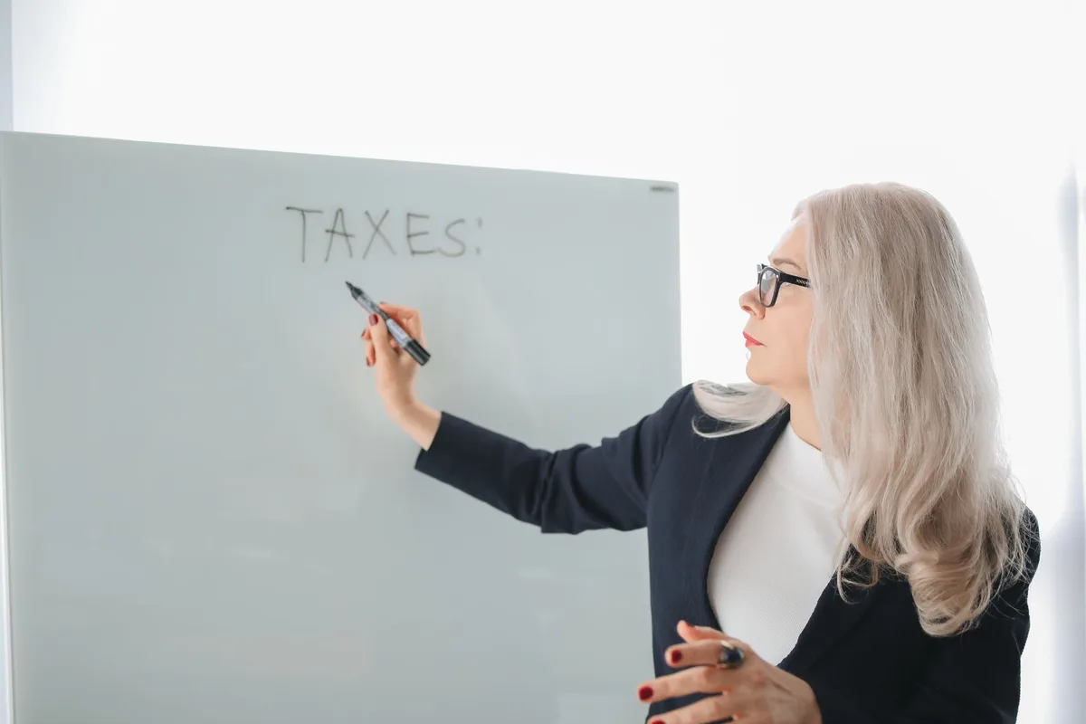 American expat professional reviewing tax documents at a modern desk in a Dubai office with city skyline visible through floor-to-ceiling windows