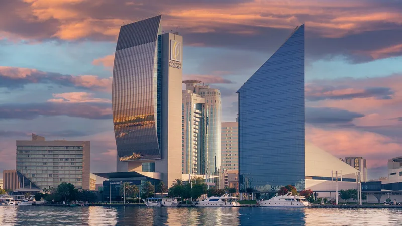 Office towers and yachts along Dubai Creek at sunset