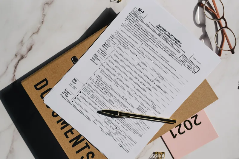 Stack of UAE company registration documents including trade license, memorandum of association, and passport copies organized on a desk — the standard documentation set for FTA registration