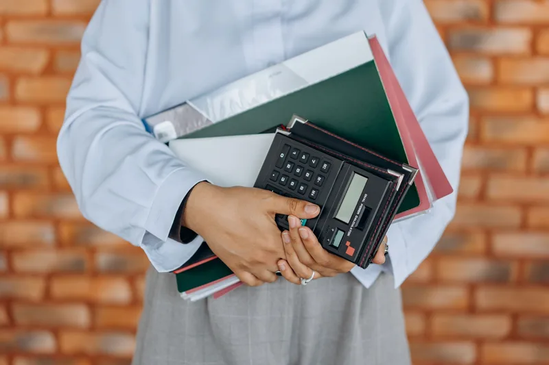 Accountant holding a calculator reviewing financial documents, representing VAT compliance review