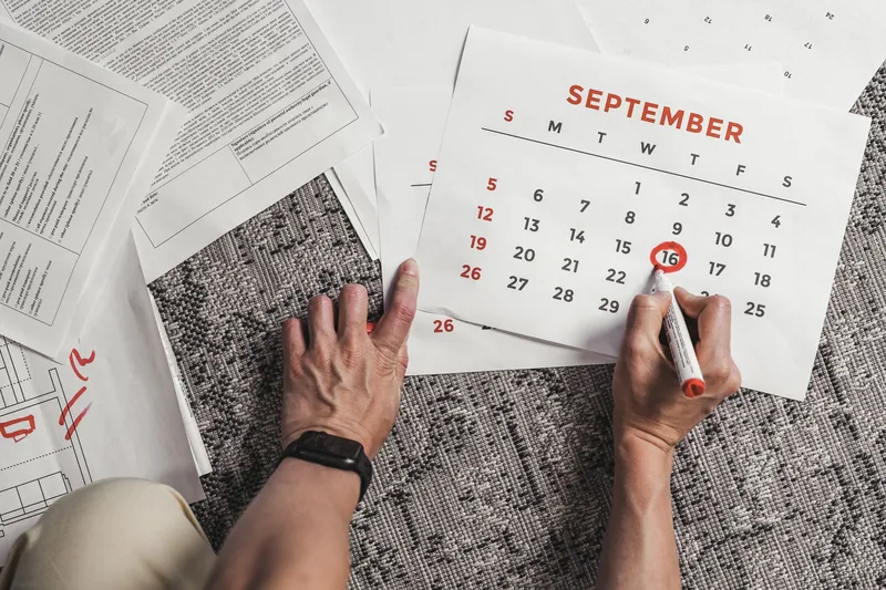 Hands holding a calendar with dates circled